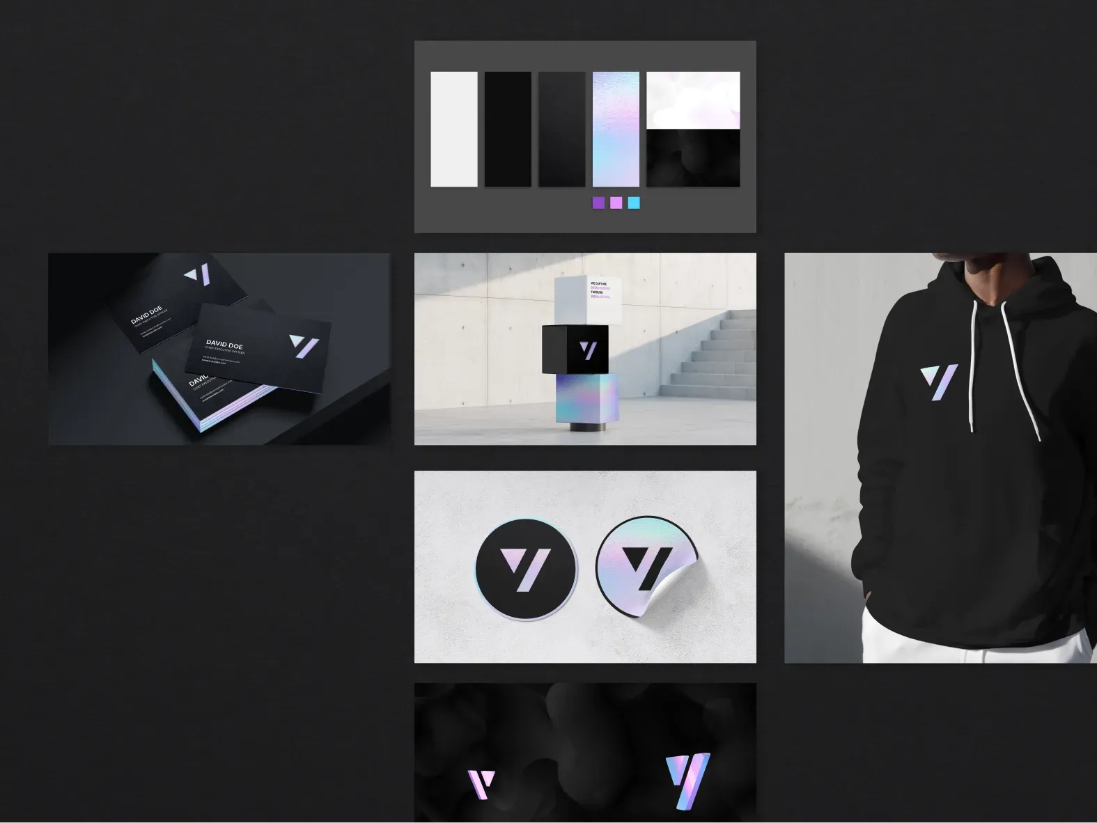 Brand applications on charcoal: a swatch board of white, black and opal surfaces, black business cards with iridescent edges, stacked cubes, two round stickers, a black hoodie and 3D marks